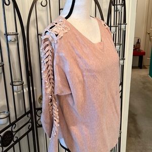 Pink sweater with pearl, lattice sleeves.